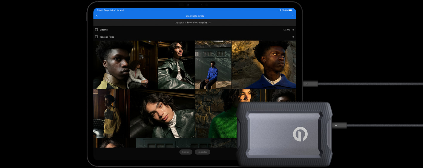 Parte da frente de um iPad Pro preto-espacial na horizontal conectado a um cabo para um disco rígido externo com USB-C. A tela mostra fotos de modelos sendo importadas para uma pasta chamada 'Campanha de Fotos'