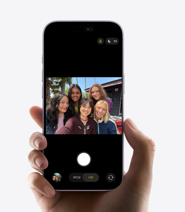 iPhone 17의 앞면, 사진을 위한 센터 스테이지 기능을 사용해 단체 셀피를 찍고 있는 모습