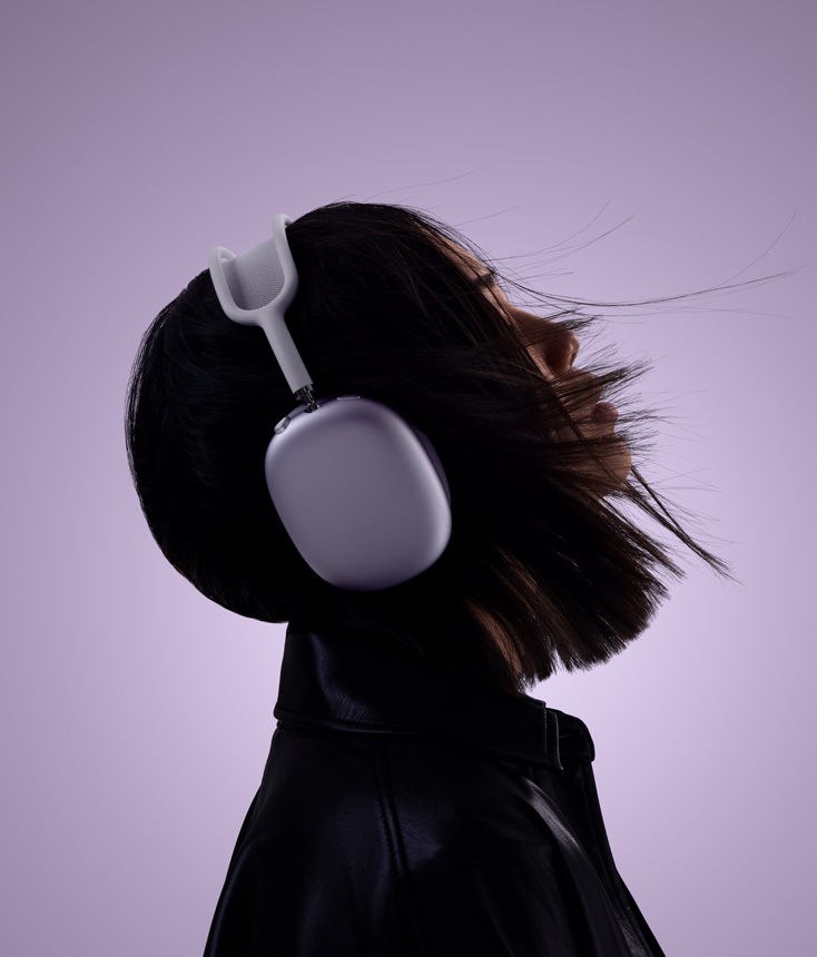 صورة سيدة تضع على رأسها سماعات الرأس AirPods Max 2 بلون ليلكي ورأسها مائل إلى الأعلى قليلاً
