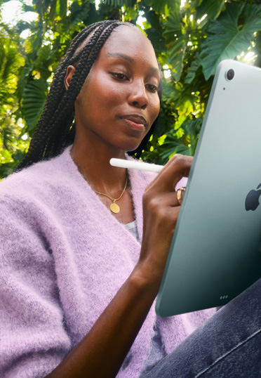 屋外で座っている学生。iPadとApple Pencil Proを持っている